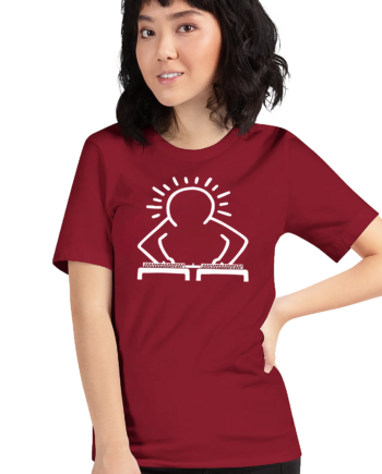 This women’s dark red t-shirt showcases a stylized white line illustration of a DJ behind turntables, rendered in a design reminiscent of Keith Haring’s famous pop art style. The DJ’s head is surrounded by radiating lines, symbolizing rhythm, movement, and sound. Inspired by Haring’s A Very Merry Christmas series and DJ culture, the graphic fuses 1980s street art with modern hip hop aesthetics, creating a lively, art-inspired fashion statement that celebrates music and artistic expression.